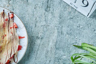 Dondurmalı krep, beyaz tabakta çilek ve çikolata.