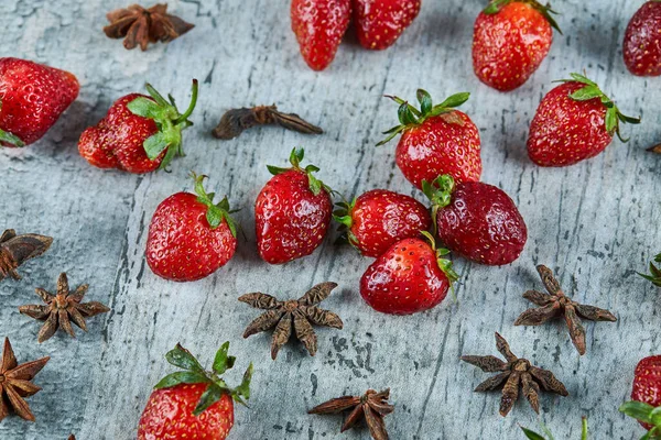 Frische rote Erdbeeren und Nelken auf Marmor-Hintergrund — Stockfoto