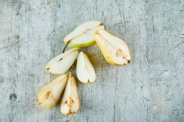 Gri arka planda izole edilmiş olgun armut dilimleri