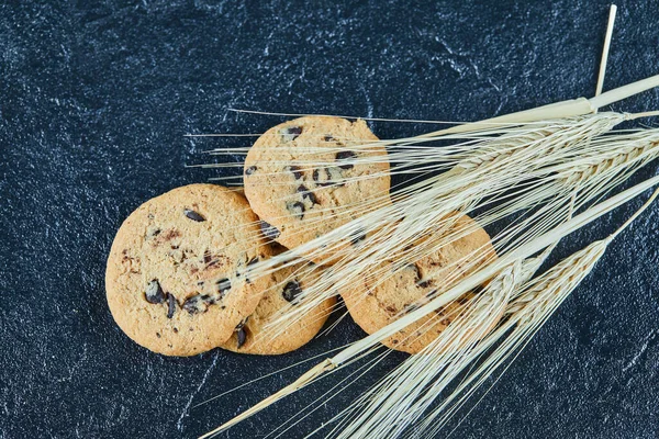 Печенье с шоколадной крошкой на мраморном фоне с колосьями пшеницы — стоковое фото