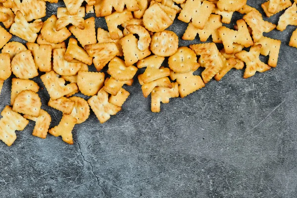 Scattered alphabet crackers on a marble background — Stock Photo, Image