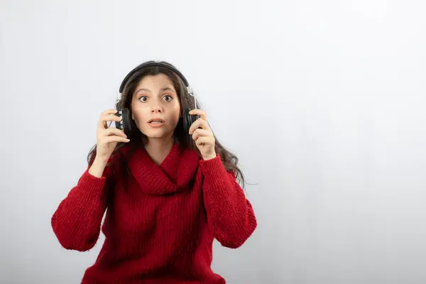 Uma mulher surpresa ouvindo música usando fones de ouvido — Fotografia de Stock