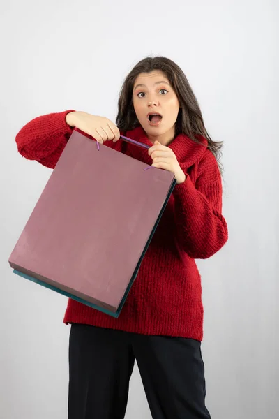 Foto de uma senhora chocada segurando sacos de compras coloridos — Fotografia de Stock