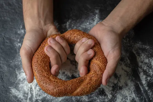 Nő gazdaság friss török simit fekete háttér — Stock Fotó