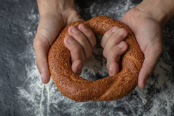 Női kéz kezében friss török simit fehér fekete — Stock Fotó