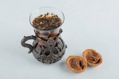 Ceviz şeklinde kurabiyeli bir fincan bitki çayı.