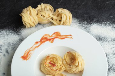 Beyaz bir tabak unlu pişmemiş erişte.