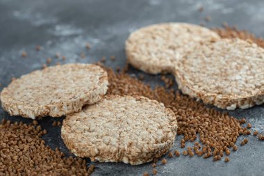 Kabarmış çıtır ekmek ve mermer yüzeyde çiğ karabuğday.