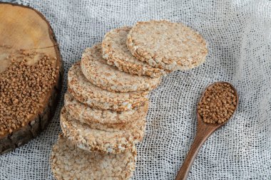 Lezzetli çıtır ekmek ve beyaz çuval bezi üzerinde bir kaşık karabuğday.