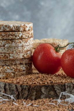 Bir yığın pirinç keki, domates ve çiğ karabuğday.