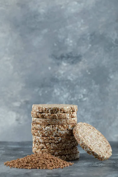 Montón de pan crujiente y montón de trigo sarraceno en la superficie de mármol —  Fotos de Stock