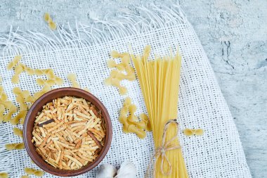 Sarımsaklı mermer zemin üzerinde pişirilmemiş makarna çeşitleri