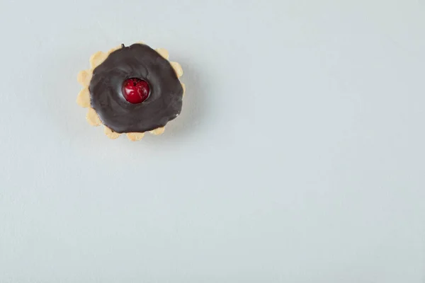 Chocolade tartalette met rode kers op de bovenkant — Stockfoto