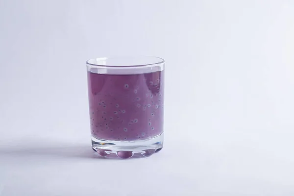Un vaso de jugo de arándano púrpura sobre fondo gris — Foto de Stock