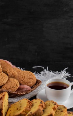 Bir fincan çayla servis edilen ahşap tabakta kurabiyeler.