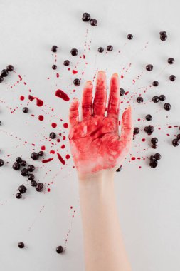 Beyaz arka planda kuşüzümü ziyareti ve bir adamın elinde kırmızı şurup.