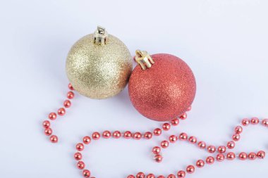 Beyaz arka planda kırmızı inci zincirli Noel ağacı topları
