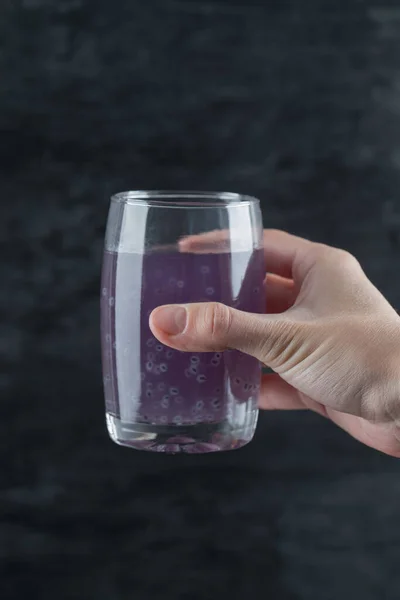 Una persona sosteniendo un vaso de jugo púrpura — Foto de Stock