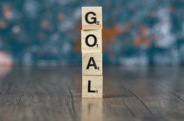 Ahşap zemin üzerindeki tahtadan zarlarda siyah harflerle amaç yazımı