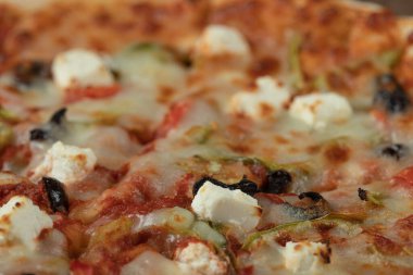 Karışık malzemeli ve doğranmış beyaz peynirli pizza.