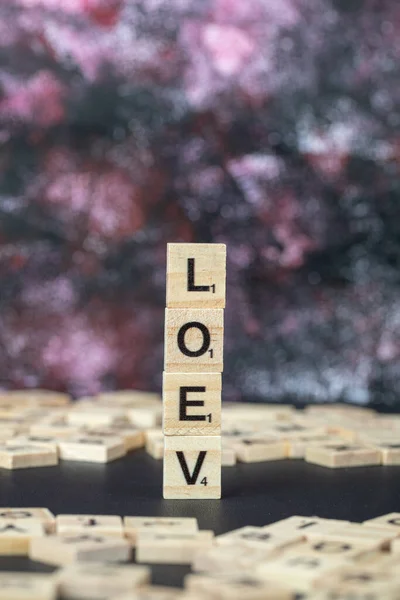 Amor ou loev escrita simbólica com letras pretas em dados de madeira — Fotografia de Stock