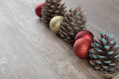 Ahşap bir güvertede doğal meşe ağacı konileri. Etrafında göz alıcı süsler var.