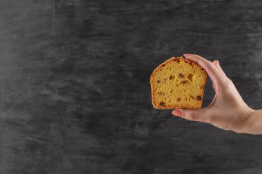 İçinde siyah sultana olan bir dilim turta tutuyorum.