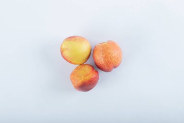 Masmavi arka planda, gölgeli olgun şeftaliler.