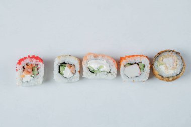 Beyaz arkaplanda izole edilmiş suşi rulolarının çeşitliliği