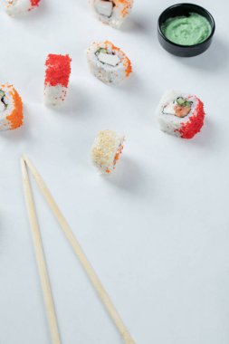 Sushi, Wasabi ile beyaz arka planda karışımı yuvarlıyor.