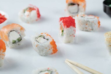 Kırmızı havyarlı suşi ruloları ve beyaz arka planda izole edilmiş somon.