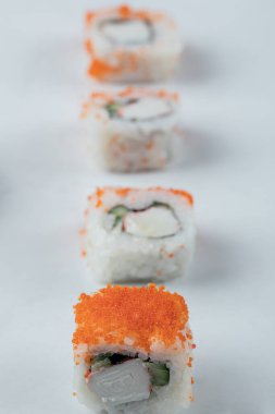 Beyaz arka planda izole edilmiş krem peynirli somon ruloları.