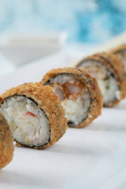 Kızarmış sıcak suşi ruloları beyaz arka planda izole edilmiş.