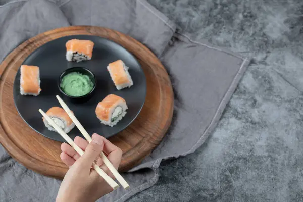 Lax maki rullar i en vit platta med wasabi sås — Stockfoto