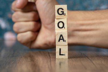 Ahşap zemin üzerindeki tahtadan zarlarda siyah harflerle amaç yazımı