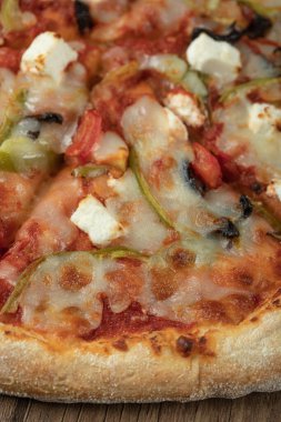 Karışık malzemeli pizza ve üstünde erimiş peynir.