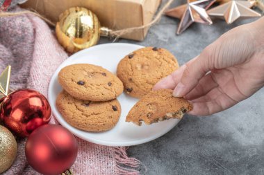 Beyaz çay tabağından bir parça yulaflı kurabiye alıyorum.