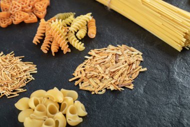 Koyu arkaplanda çiğ makarna çeşitleri