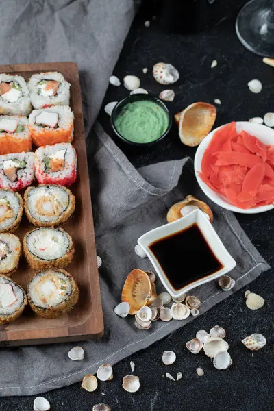 Sushi satt på en träskiva med sojasås och ingefära — Stockfoto