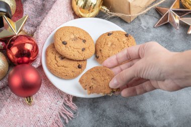 Beyaz çay tabağından bir parça yulaflı kurabiye alıyorum.