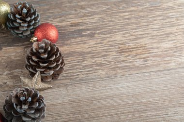 Ahşap bir güvertede doğal meşe ağacı konileri. Etrafında göz alıcı süsler var.