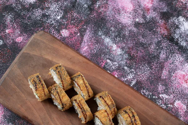 Rollos fritos de sushi caliente en una tabla de madera — Foto de Stock