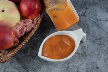 Şeftali ve elmalar ahşap bir sepetin içinde pembe bir havlu parçasında