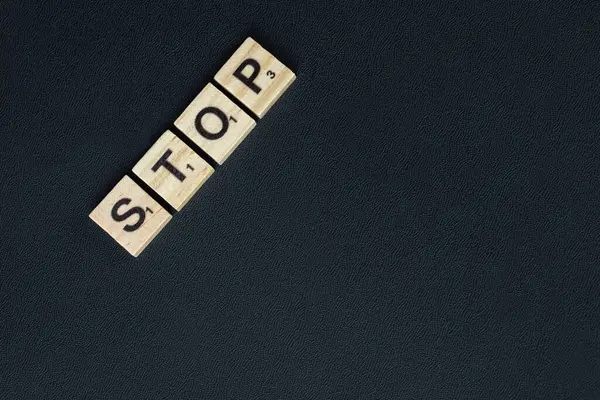 Зупинити символічний запис чорними літерами на дерев'яних дужках горизонтально — стокове фото