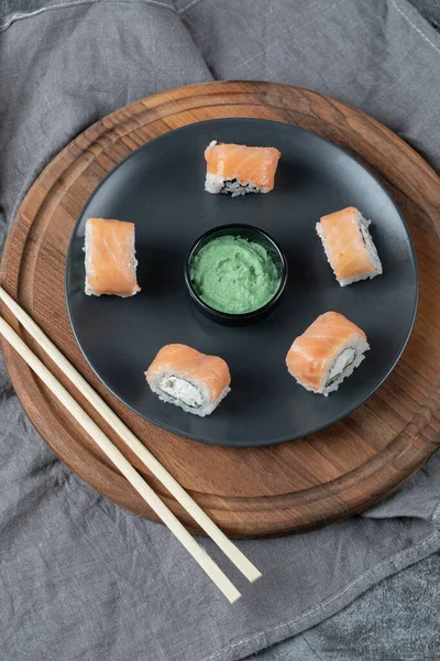 Lax rullar i ett svart fat med wasabi sås — Stockfoto