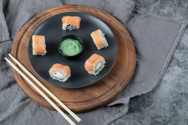 Lax maki rullar i en vit platta med wasabi sås — Stockfoto