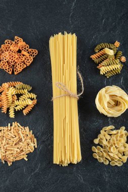 Koyu arkaplanda pişmemiş makarna çeşitleri