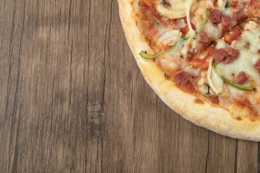 Karışık malzemeli pizza ve üstünde erimiş peynir.