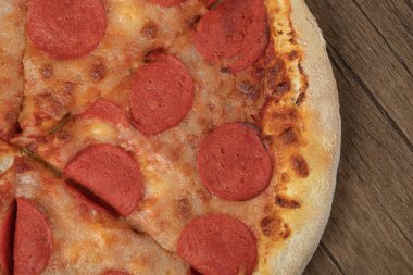 Pepperoni dilimli pizza ve üstüne erimiş peynir.