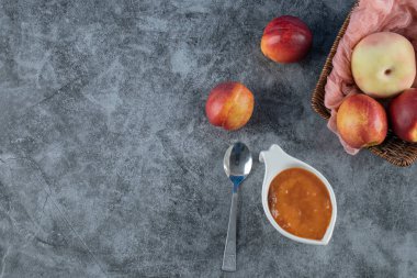 Şeftali ve elmalar ahşap bir sepetin içinde pembe bir havlu parçasında